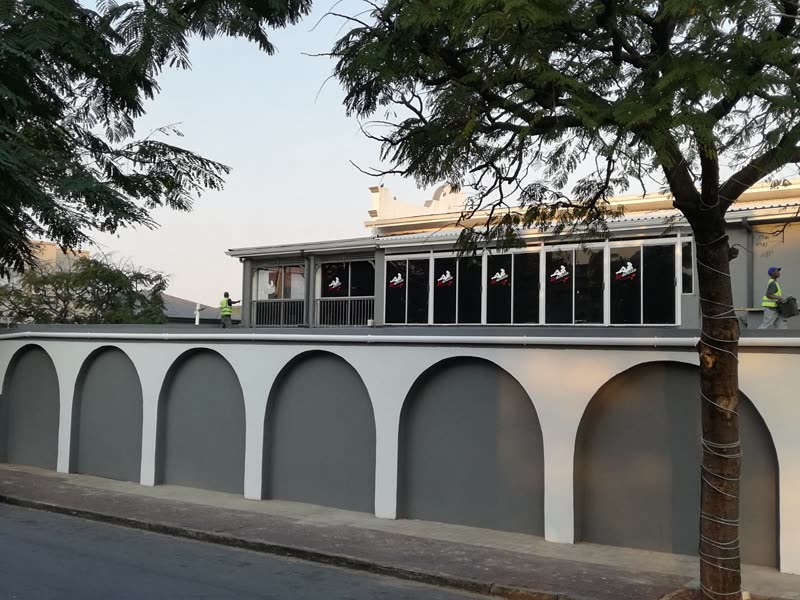 Completed arched boundary wall running along the street frontage of a building