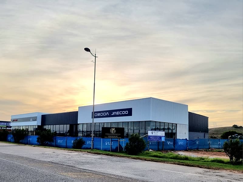 Completed motor dealership with a glazed showroom frontage at sunset