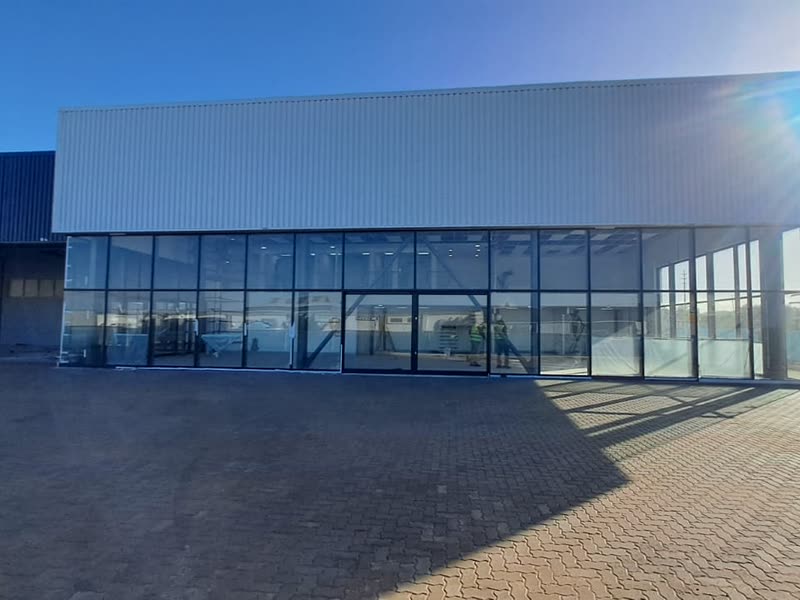 Completed showroom building with full-height glazing and profiled cladding
