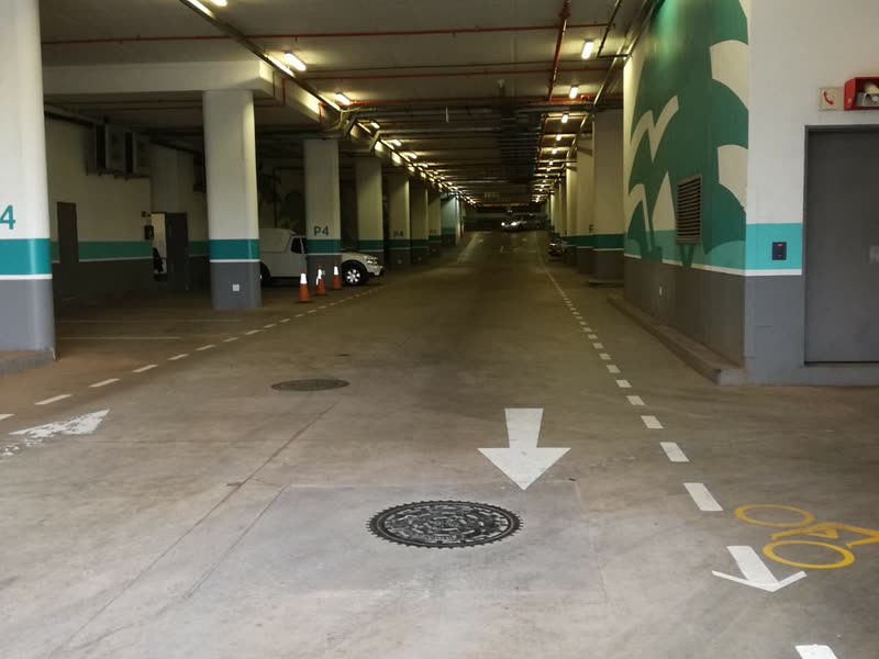 Long run of completed basement parking with lighting and directional markings