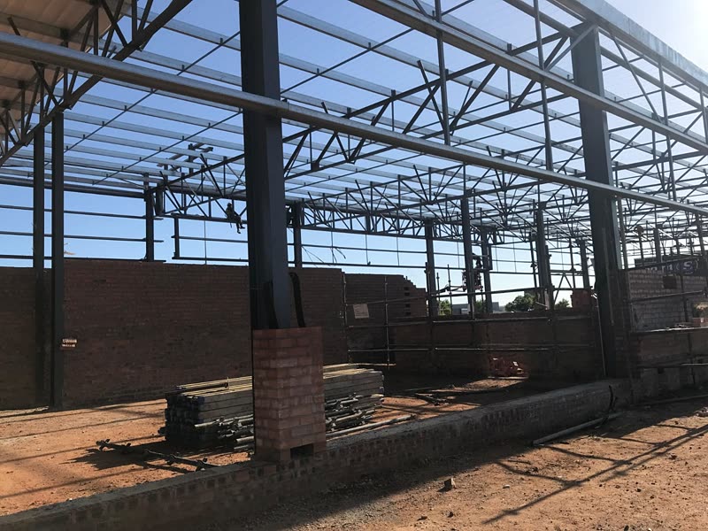 Internal view of a steel-framed building with the brick envelope going up