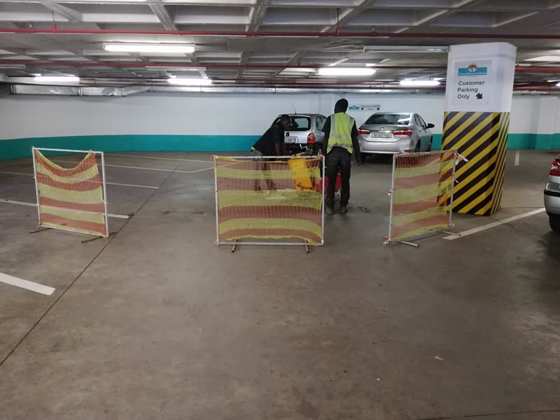 Parking deck under refurbishment with barriers in place and bays being reworked
