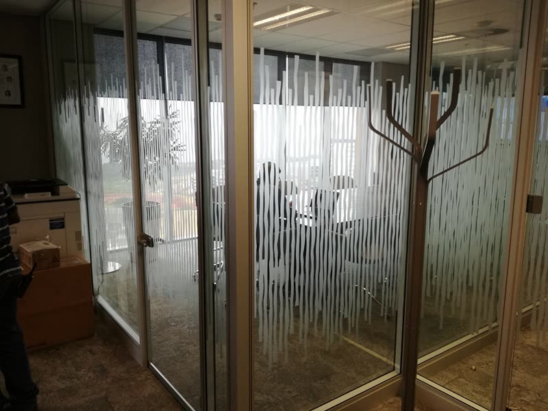Detail of a glazed partition junction and door set in a fitted-out office