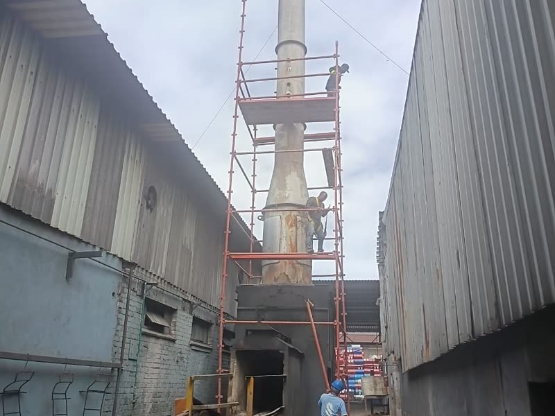 Industrial stack works viewed along the service alley between factory buildings
