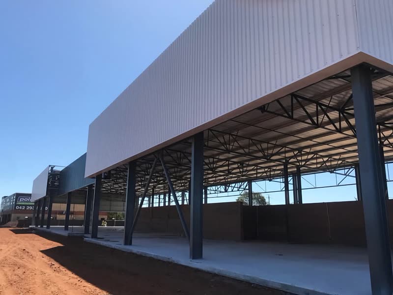 Steel-framed industrial building with the roof sheeted and walls under way