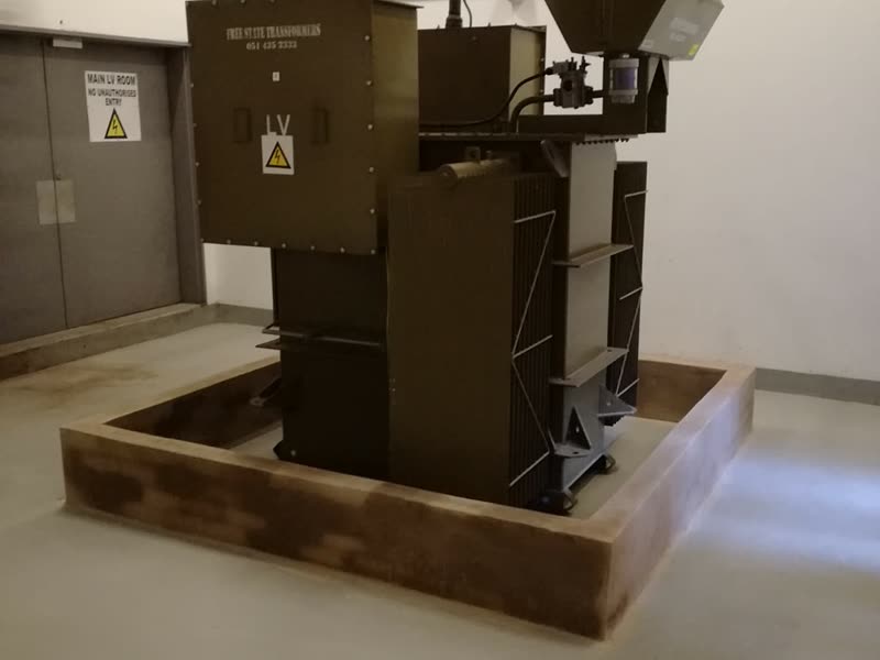 Medium-voltage transformer installed on a bunded plinth in a substation room