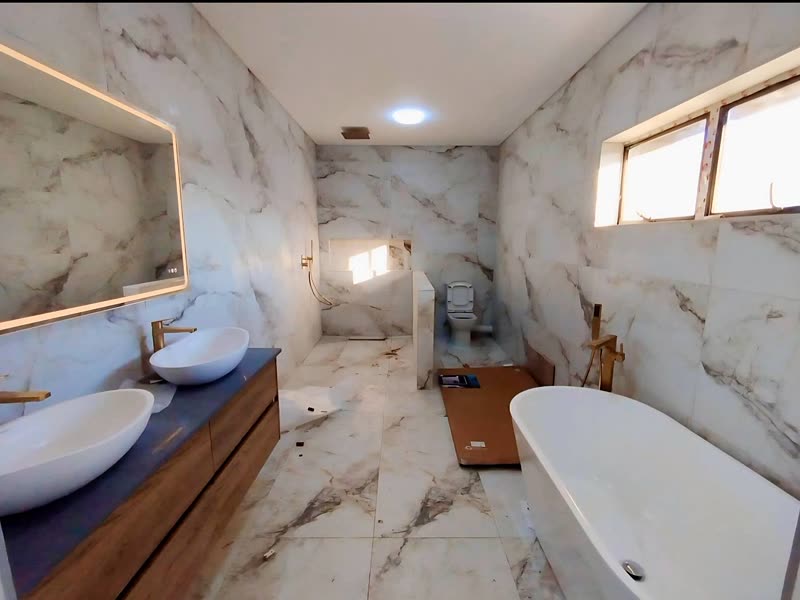 Main bathroom with a freestanding bath and full-height marble-effect tiling