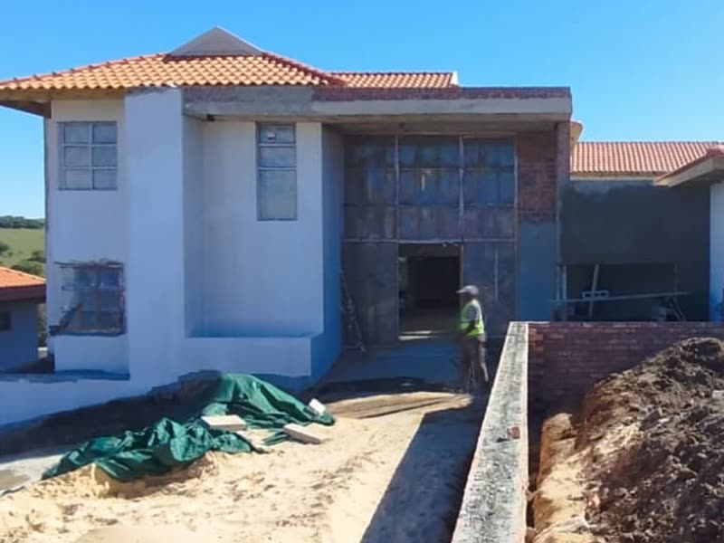 Face-brick boundary walling under construction alongside a house being built