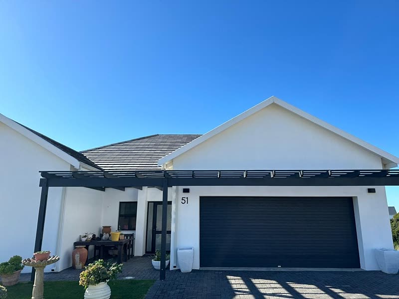 White rendered home with pergola, planted courtyard and double garage