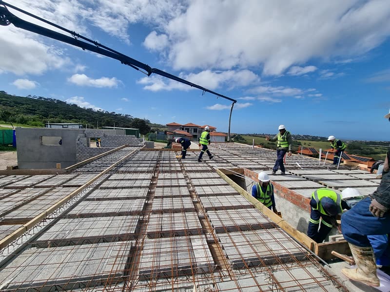 Concrete being placed by pump across a rib-and-block deck with the team working it