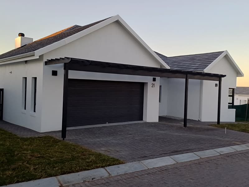 Completed single-storey home photographed at dusk with the garage closed