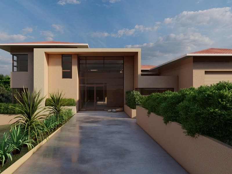 Completed contemporary home in ochre render with a landscaped entrance driveway