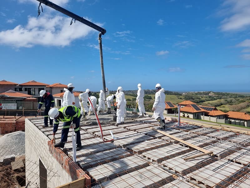 Concrete being placed and worked across a suspended slab by the site team