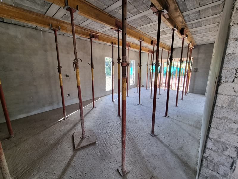 Interior of a house under construction with the slab above still fully propped