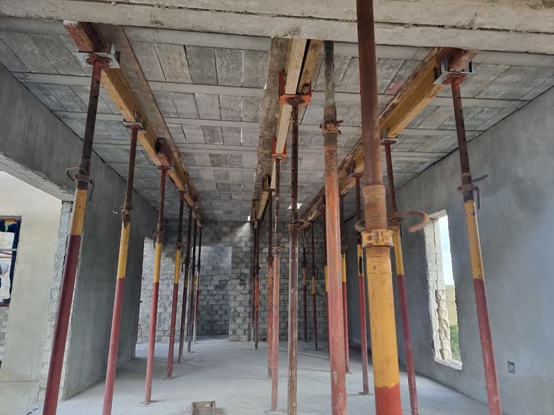 Freshly cast slab soffit still on props above a block-walled ground floor