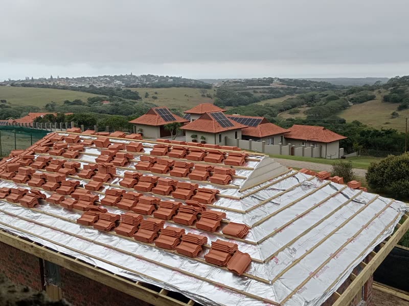 Roof tiles loaded out and being laid over battens on a new roof