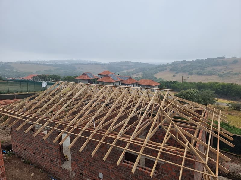 Timber roof trusses erected and braced over a completed brick superstructure