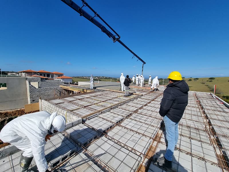 Concrete pump boom over a reinforced slab with the site team in position