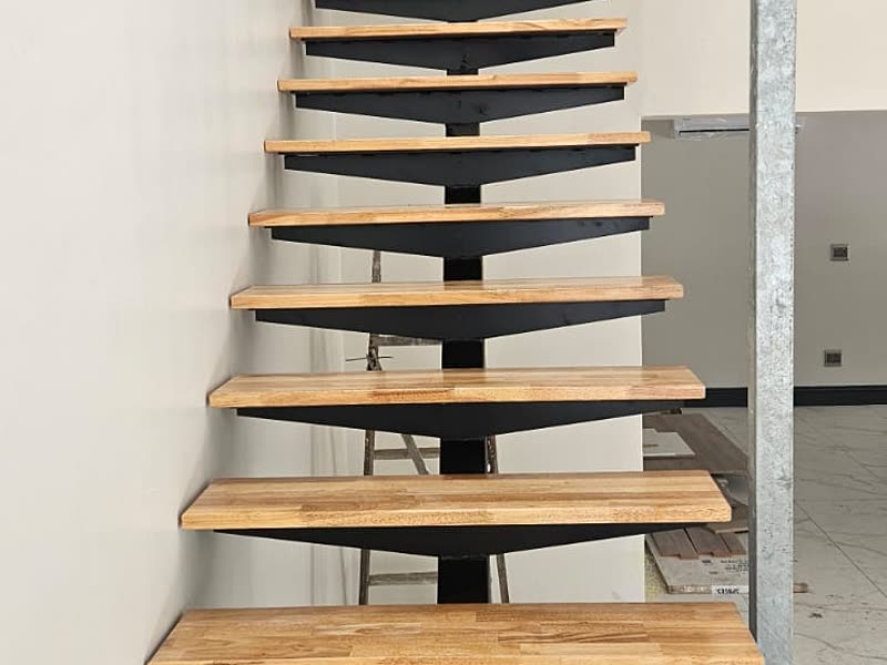 Cantilevered timber staircase with a glass balustrade in a double-volume space