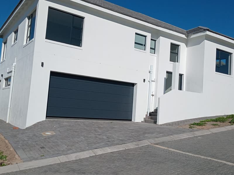 Double-storey home seen from the street with garage and paved apron