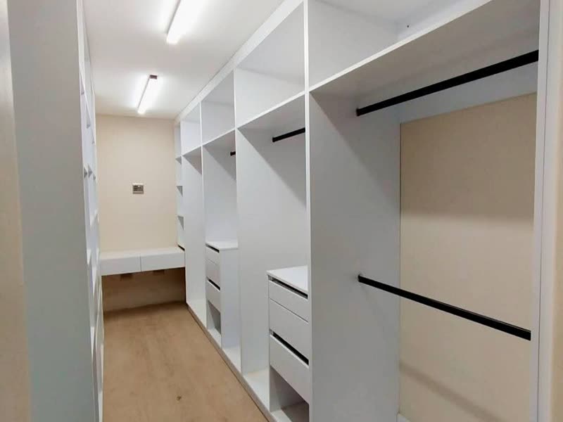 Fitted walk-in wardrobe in white joinery with open shelving and drawers